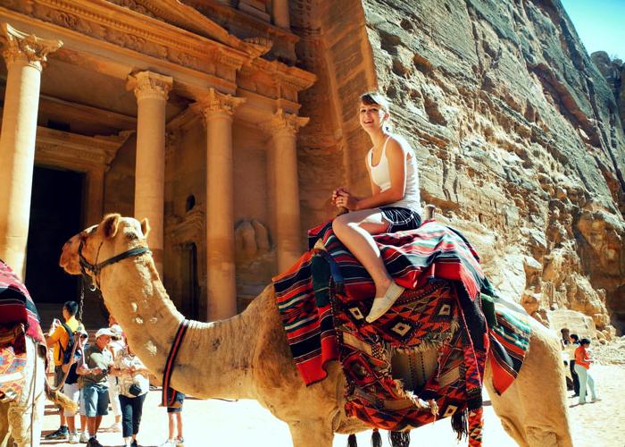 约旦佩特拉，一个女孩骑着骆驼